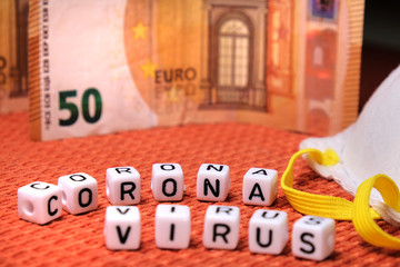 Text coronavirus word, white protective mask, european money euro on a fabric  background.