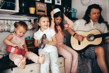 large family with 4 children plays music at home