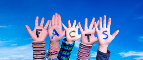 Children Hands Building Colorful English Word Facts. Blue Sky As Background