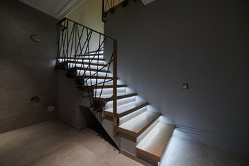 Stairs to the top. Design stairs made of metal and wood. backed up. Metal railing in black
