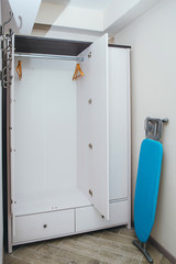 Close up of wardrobe with wooden clothes hanger, one blue iron table.