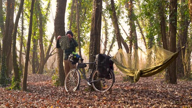 Establishing shot of man hanging clothes while camping during winter, Croatia.