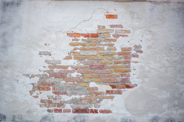 white brick wall with peeling stucco