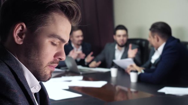 Indifferent executive ceo experiencing confusion, feels trouble doubt, looks for solution problem during conference discussion of coworkers indoor. Concern, strategy dilemma of uncertain worried chief