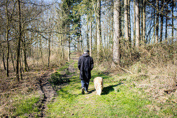 Alter Mann Senior spaziert allein mit Hund im Wald Social Distancing wegen Corona