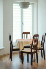 Eating area in home. Dining table and four chairs closeup. Concept of cozy family meal.