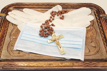 asking for divine help, tray with mask, latex gloves and a rosary with a cross, by covid-19,...