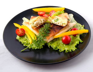 Pita triangles with cottage cheese, herbs, tomatoes on a black and white plate
