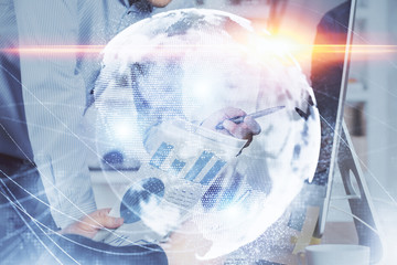 Double exposure of businessman working on laptop on background. International business hologram in front. Concept of success.