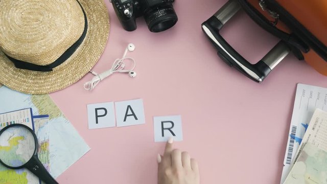 Top view hands laying on pink desk word PARIS