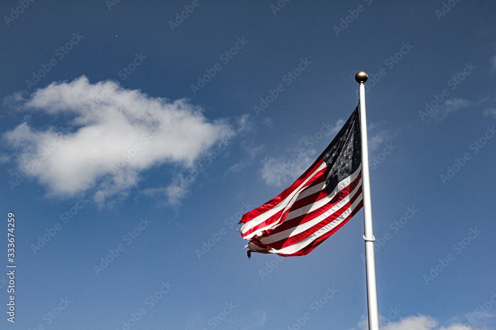 Wall mural american flag waving in the wind against blue sky