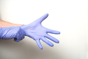 closeup of hands of doctor wearing a latex gloves to protect against the coronavirus pandemic on white background