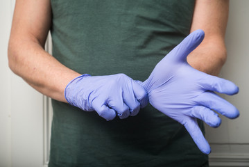 closeup of hands of doctor wearing a latex gloves to protect against the coronavirus pandemic