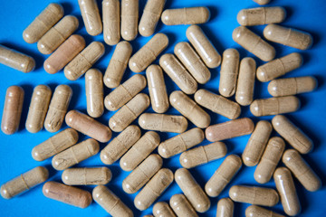 Tablets, vitamins, or medications are placed on a bright colored background.