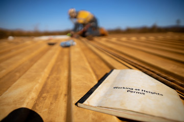 Work safe practices working at heights permit book with defocused trained construction rope access...