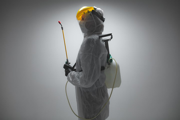 Scientist holding chemical sprayer for sterilization and decontamination of viruses, germs, pests,...