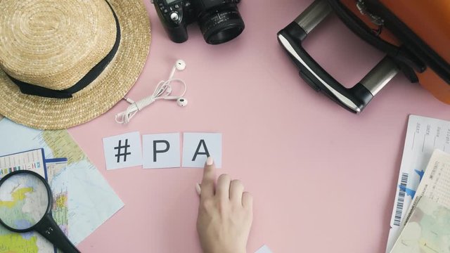 Top view hands laying on pink desk word PARIS