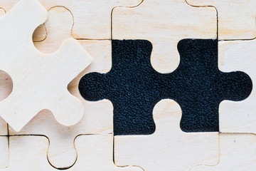 Close up wooden jigsaw puzzle pieces on black background