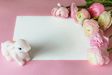 Pink paper greeting card with white frame for text, decorated with pastel pink ranunculus or...