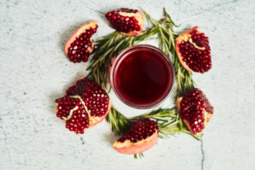 Pomegranate on a light background. Sliced ​​Pomegranate. Pomegranate juice on a light background. Juice in a glass.
