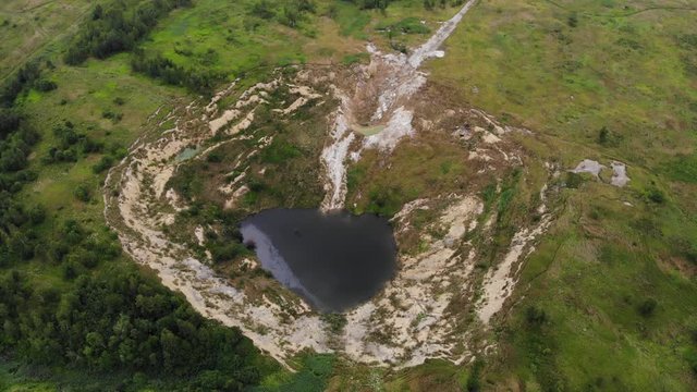 Aerial drone view of karst abyss in the land. Dangerous natural formation at the place where potash salts were once mined