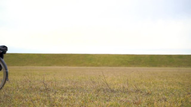 Medium shot of man pushing a bicycle in the countryside, Croatia.
