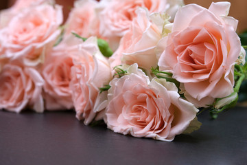 Fresh pink roses on a black background made of natural stone. Copy space