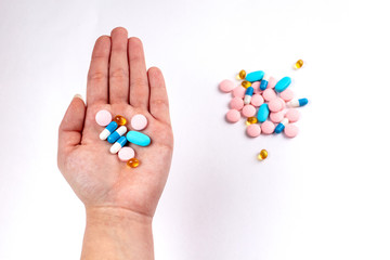 Colorfull medicine pills in left hand. blue, rose and yellow medicines and vitamins