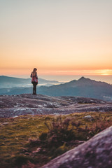 Obraz premium Silhouette of a woman contemplating the sunset from Mount Galiñeiro in Vigo, Galicia, Spain