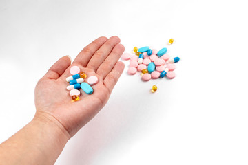 Colorfull medicine pills in left hand. blue, rose and yellow medicines and vitamins