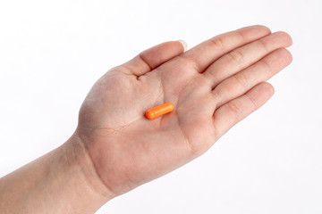 Orange pill in palm hand. medicines and vitamins