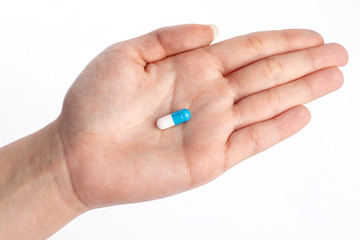 Blue and white pill in hand. medicines and vitamins