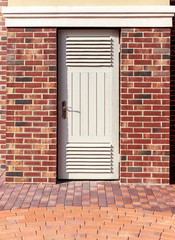 Fototapeta na wymiar white wooden door red brick wall