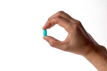 Fototapeta premium Blue vitamine in thumbs hand. medicines and vitamins