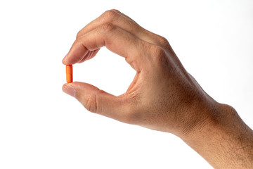 Orange vitamine in fingers hand. medicines and vitamins