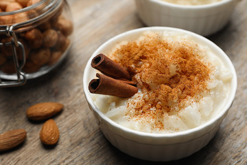 Delicious rice pudding with cinnamon on wooden table, closeup