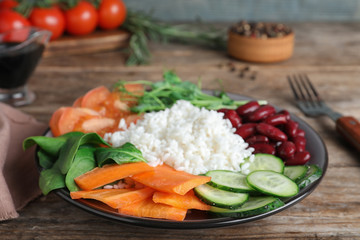 Tasty rice with beans and vegetables on wooden table, closeup
