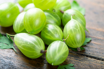 Sweet fresh gooseberry berry on wood background.