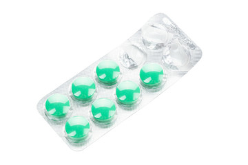 Pills green in blister packs in white background. Medicine concept.
