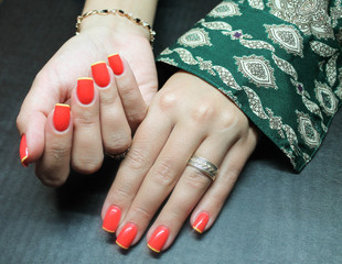 Yellow festive French on natural nails covered with red gel Polish covered with gloss on young hands of a girl © verzemnik