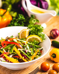 Healthy Bowl of  Arabic Salad topped with a variety of capsicum, herbs and lemon slices