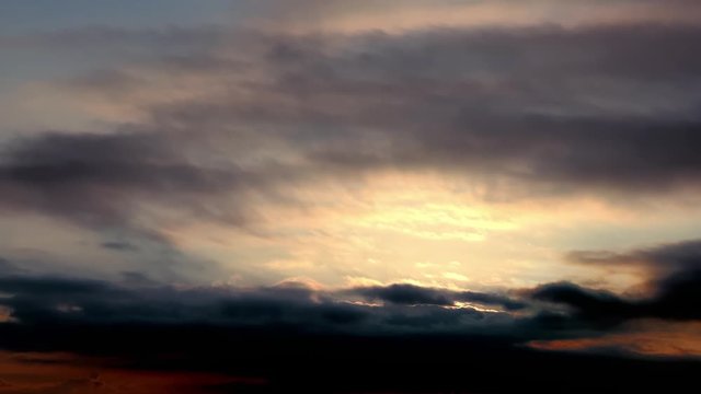 Beautiful view.Dramatic sunset. Moving cloudscape with beautiful sun. Fast moving dark blue, purple, pink, red, orange clouds in the sky. Evening sky. Clouds natural background. Cloud 4k stock footage