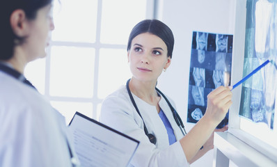 Two female doctors looking at x-rays in a hospital
