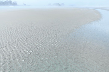 Sand forms waves on the seashore in the ocean mist. foggy skyline. sea landscape in bright colors.  Selective focus, Vancouver island, Pacific Rim National Park, British Columbia, Canada