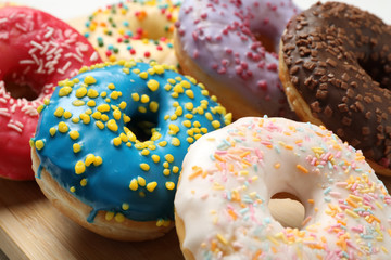 Yummy glazed donuts with sprinkles, closeup view