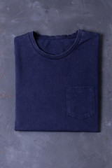 Basic navy Tshirt on grey concrete background. Mock up for branding t-shirt whith pocket. 