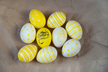 Easter eggs colored  yellow white decorated on crumpled craft paper background. Happy Easter card with copy space for text. Minimal eco easter style.
