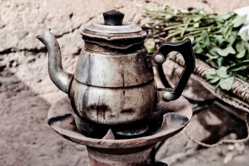 Old rusty tea pot with Moroccan mint. Vintage image.