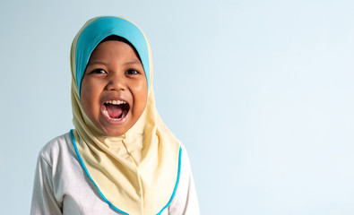 Happy and shouting Muslim girl wearing hijab isolated portrait.  Shallow depth of field