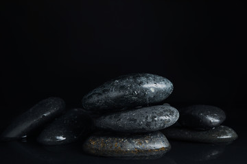 Stones in water on black background. Zen lifestyle
